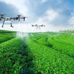 imagem de dois drones pulverizando uma lavoura.